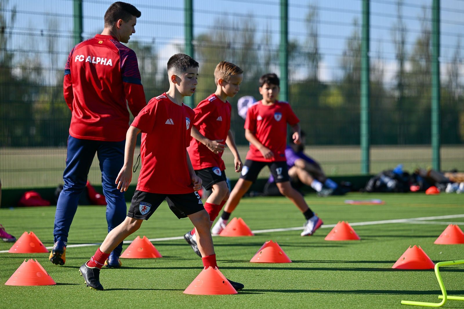 A coach guiding players through a passing drill