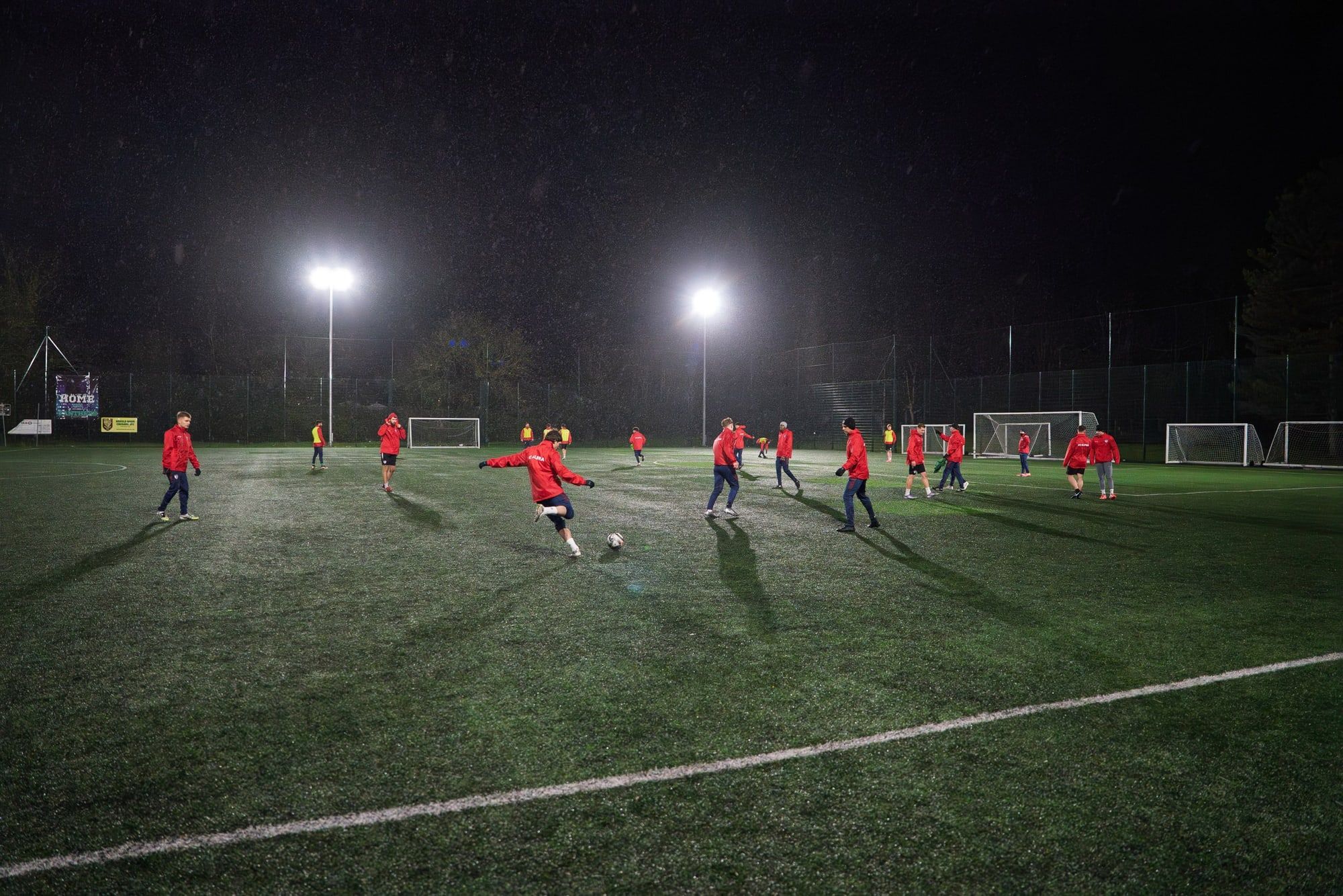Senior training under floodlights on a rainy night